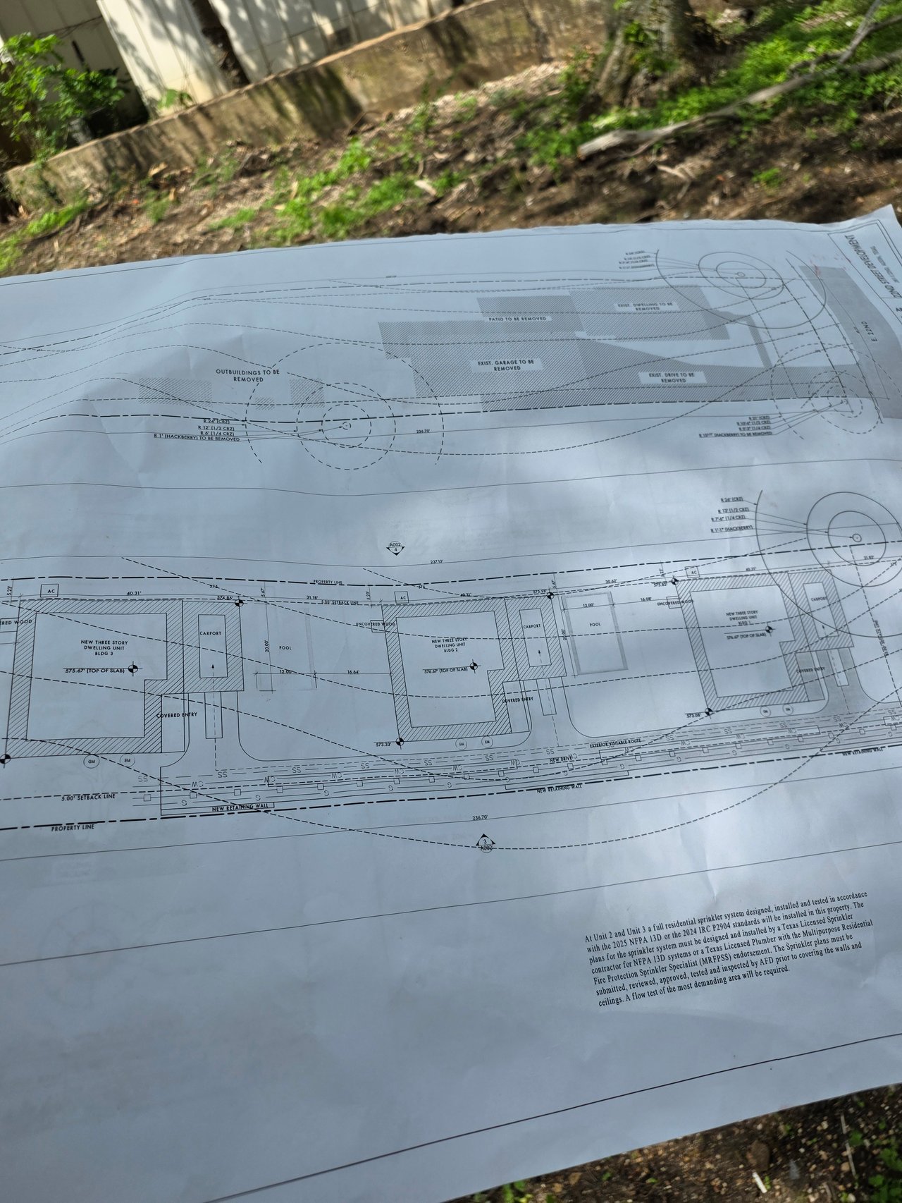 Site plan for three new three-story dwellings, pools, carports, and structures marked for removal.