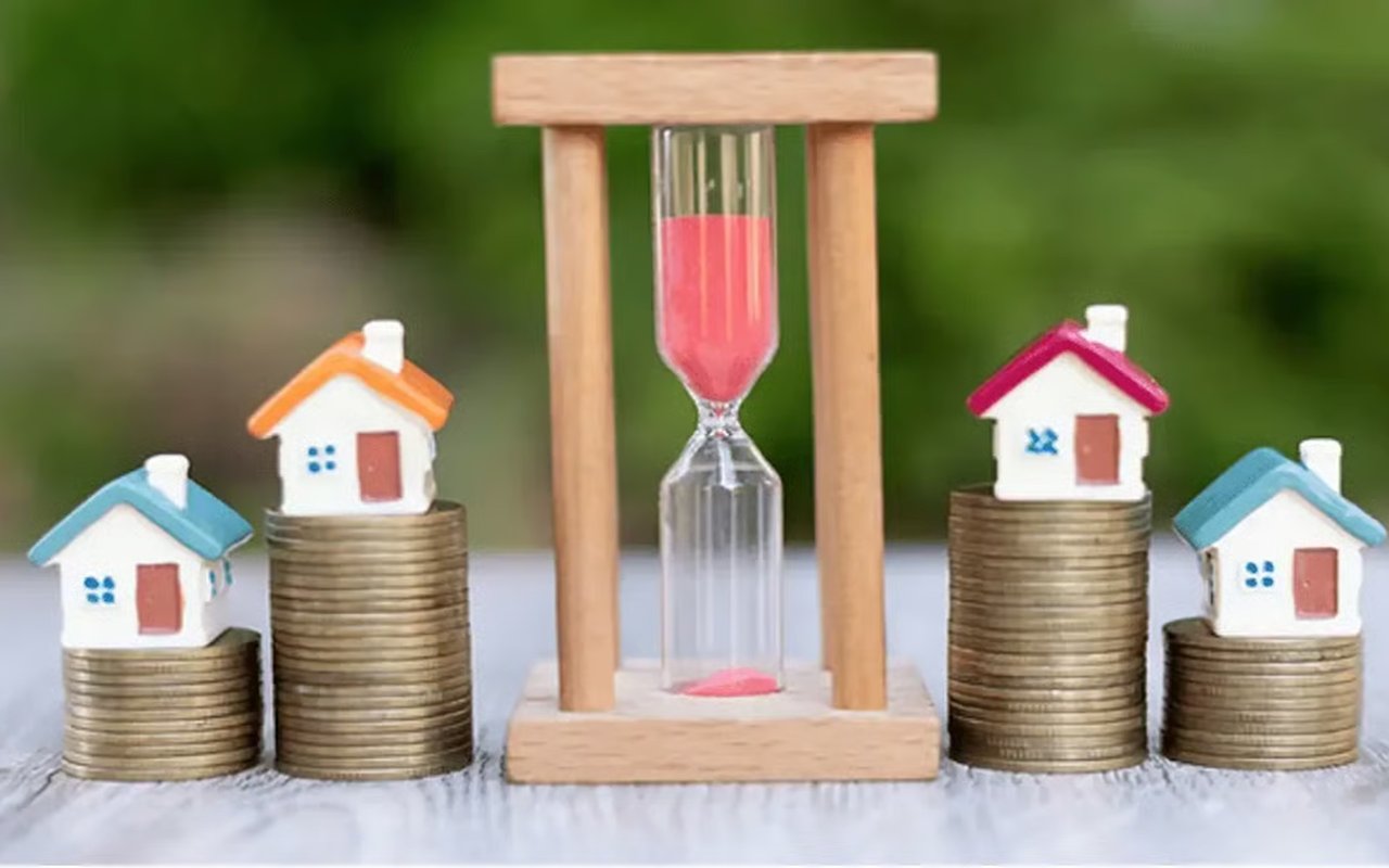 Hourglass between coin stacks topped with miniature houses