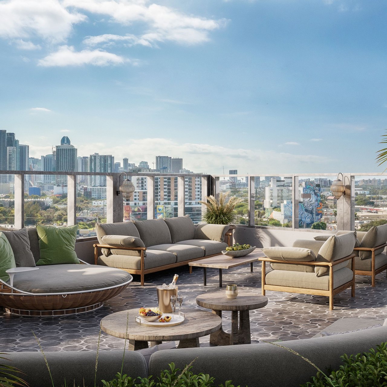 Furnished rooftop terrace overlooking a city skyline, with lounge seating and glass railings.