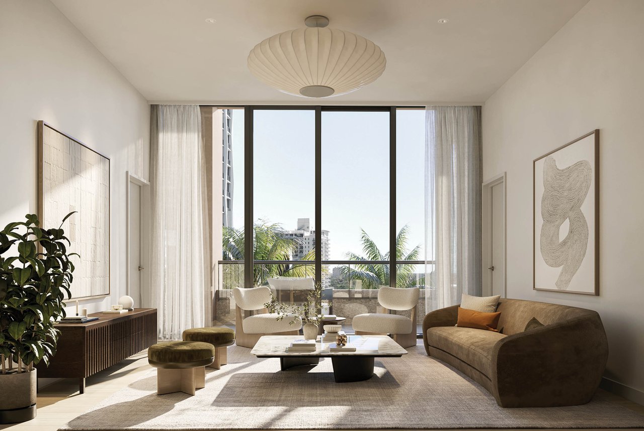 Living room with contemporary furnishings, a sculptural pendant light, and floor-to-ceiling windows overlooking palm trees.