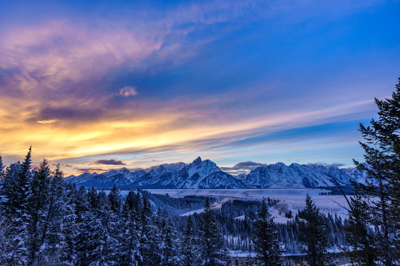 Panoramic view of luxury homes with the Teton Mountains in the background, showcasing the beauty of Jackson Hole real estate.