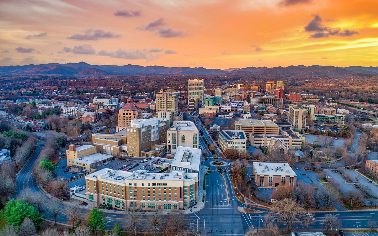Downtown Asheville at sunset, with the Blue Ridge Mountains beyond the city.