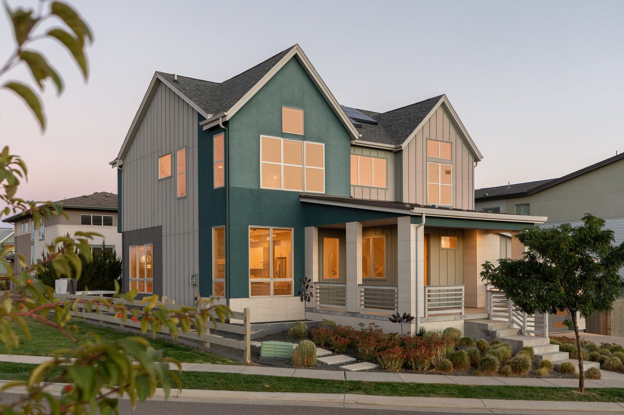 Front exterior at dusk with lit windows and the covered porch