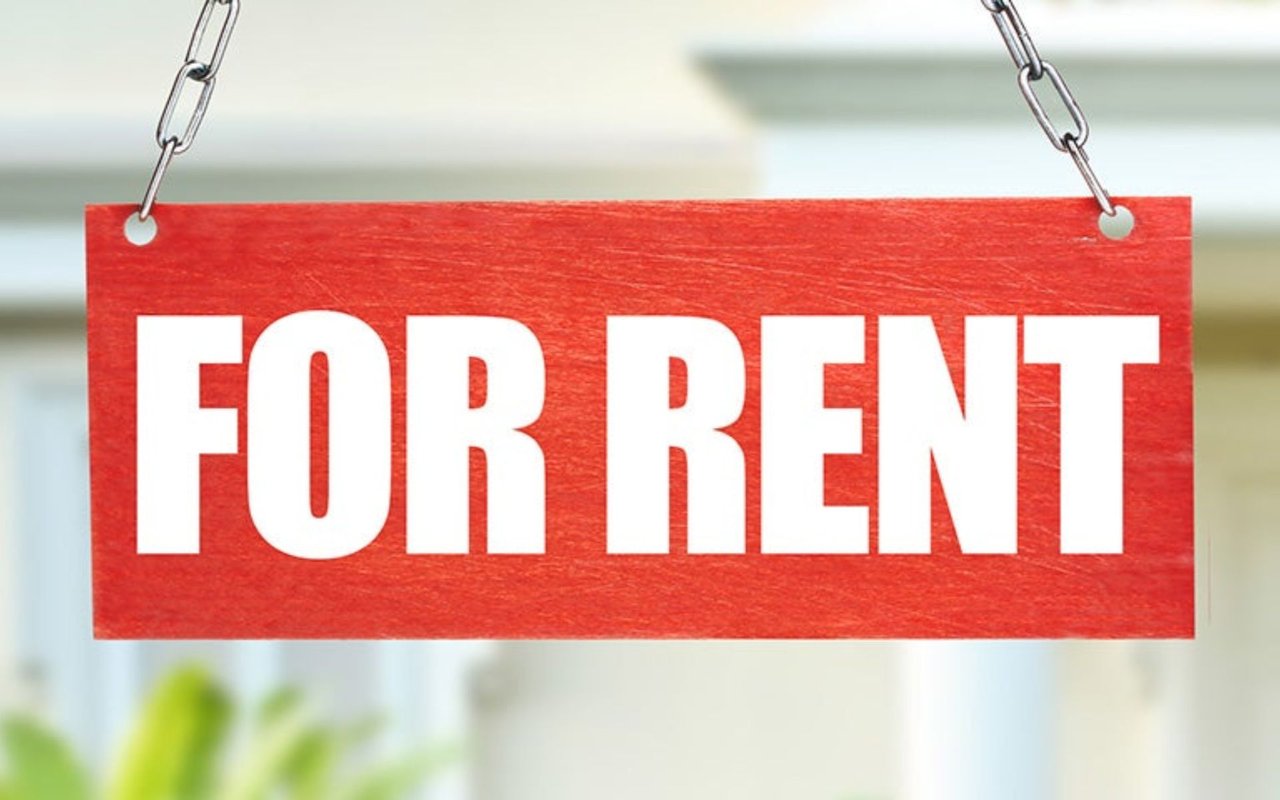 Red FOR RENT sign hanging from metal chains