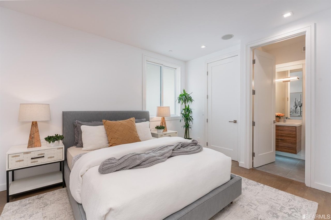 Bright bedroom with upholstered bed, nightstands, and natural light