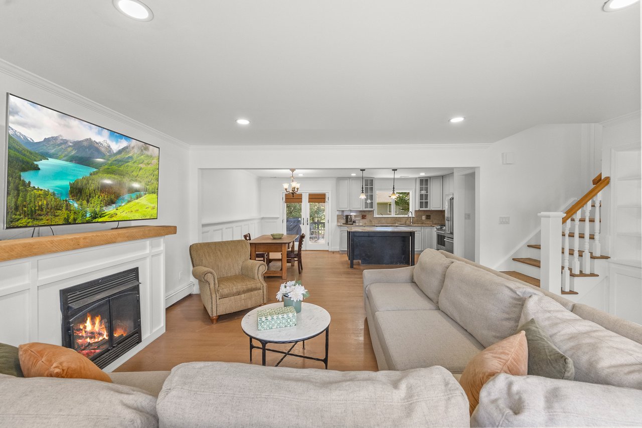 Open-concept living room with gas fireplace and view of renovated kitchen in 322 Scharer Ave, Northvale.