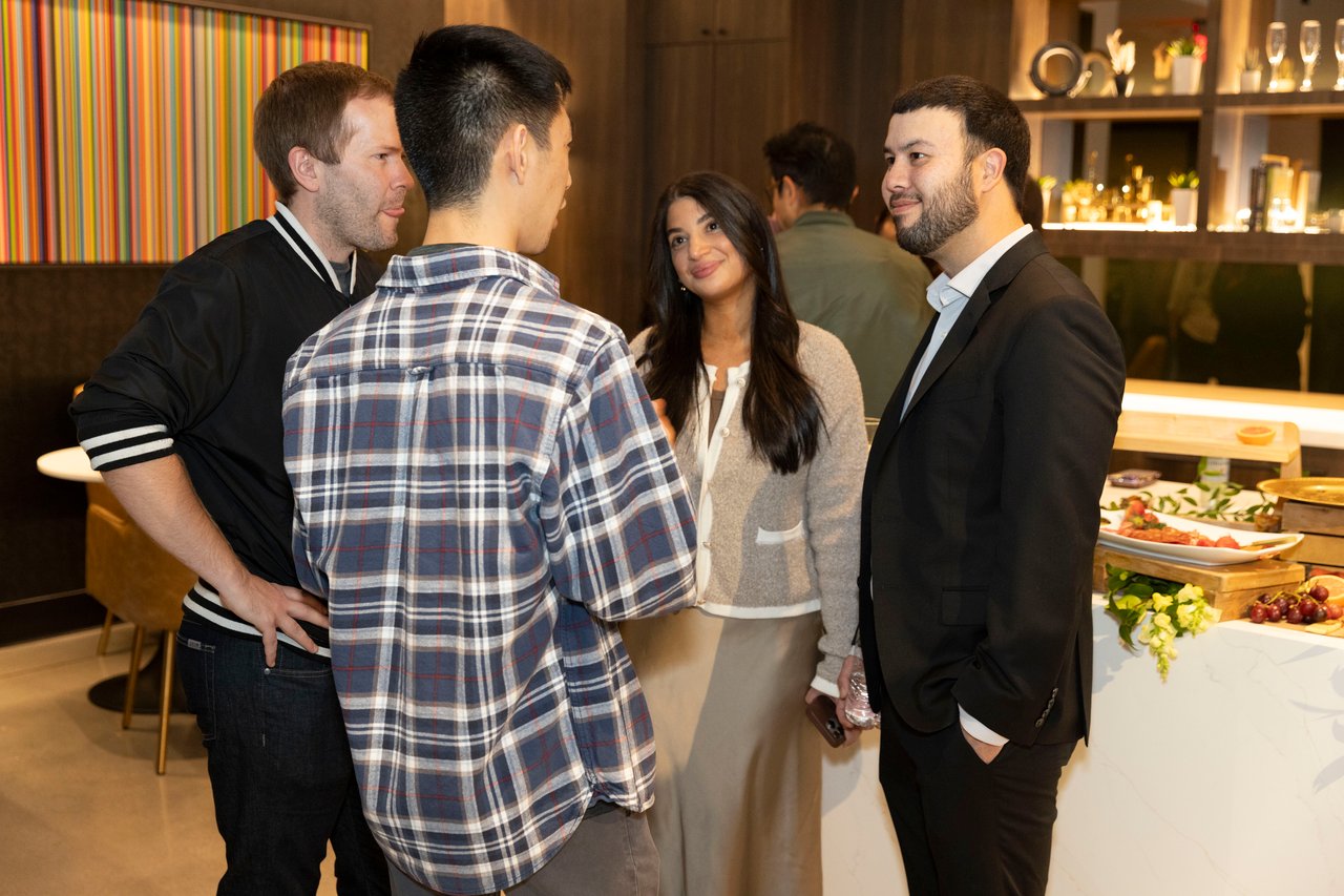 Guests mingle at an open house beside a buffet table.