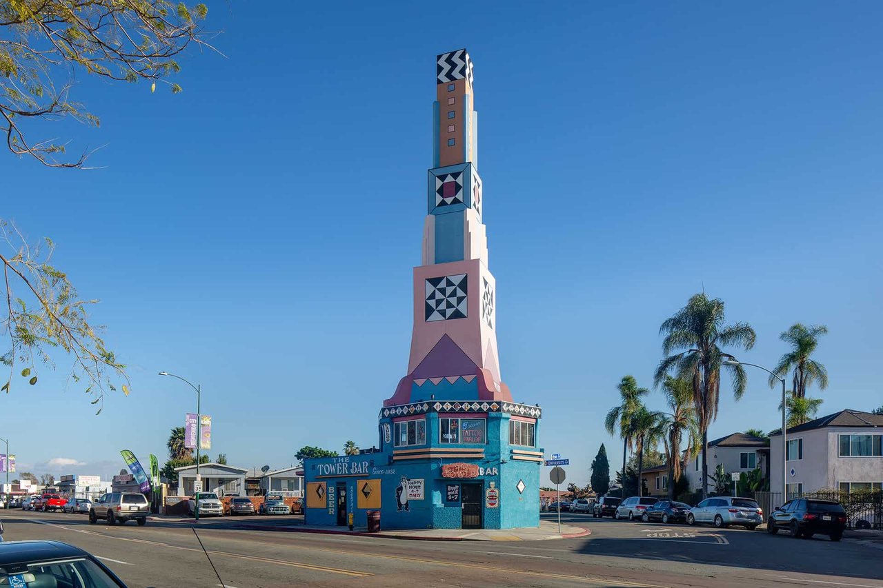 Colorful Tower Bar landmark in City Heights San Diego, surrounded by palm trees and local businesses—representing the neighborhood’s cultural vibrancy and urban real estate potential.