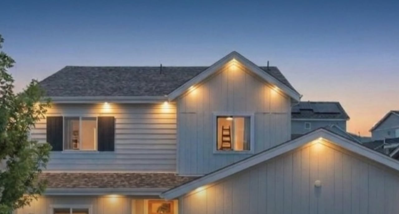 Two-story home at 9389 Blanca Street in Candelas, Arvada, Colorado, with warm exterior lighting at dusk