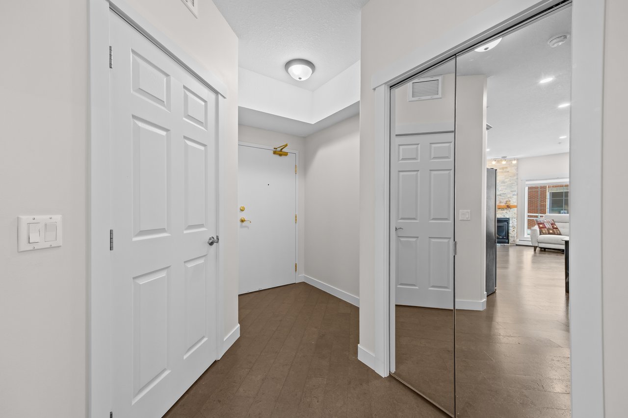 Condominium entry foyer with mirrored closet doors and a view toward the living room.