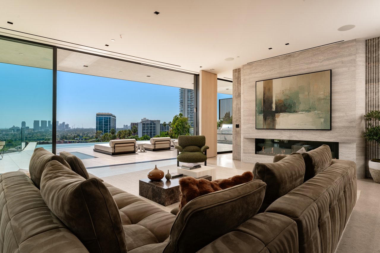 Furnished living room with floor-to-ceiling glass, a linear fireplace, and city views.
