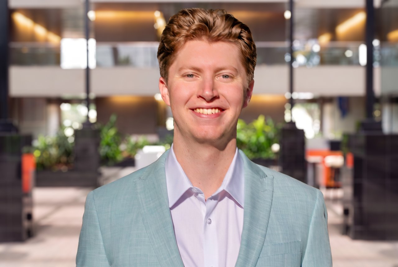 Jared Starnes wearing a light blue suit in a modern office atrium.