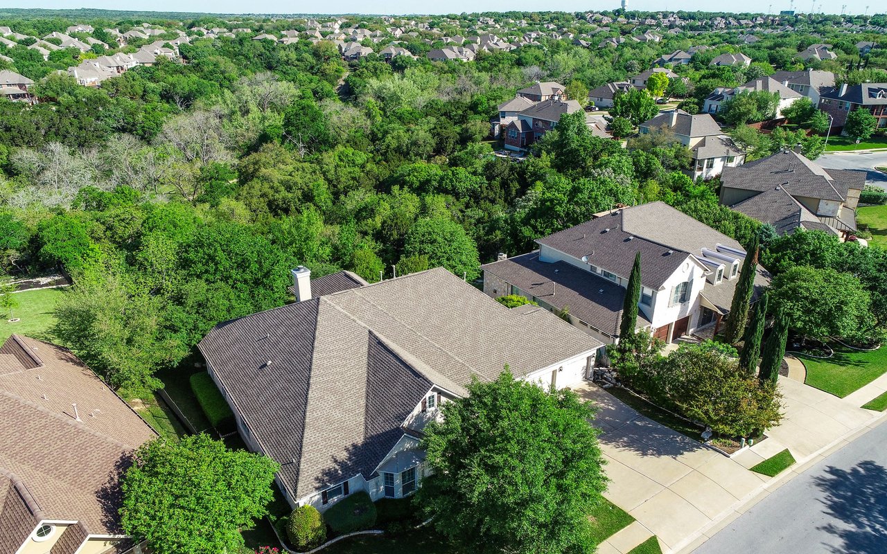 Aerial view of homes along tree-lined streets in a leafy residential neighborhood.