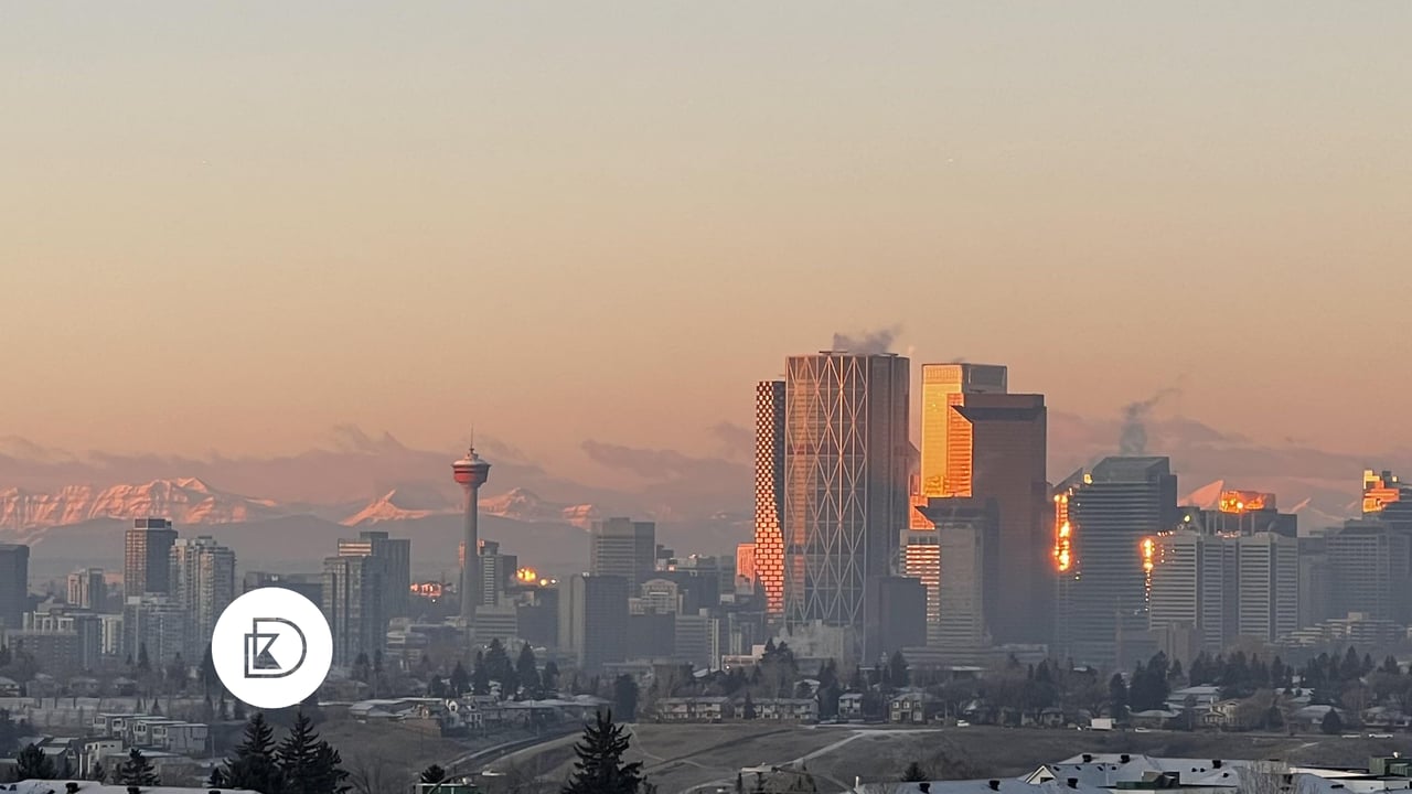 Early winter photo of downtown calgary, the calgary tower, with the mountains in the background at dusk 