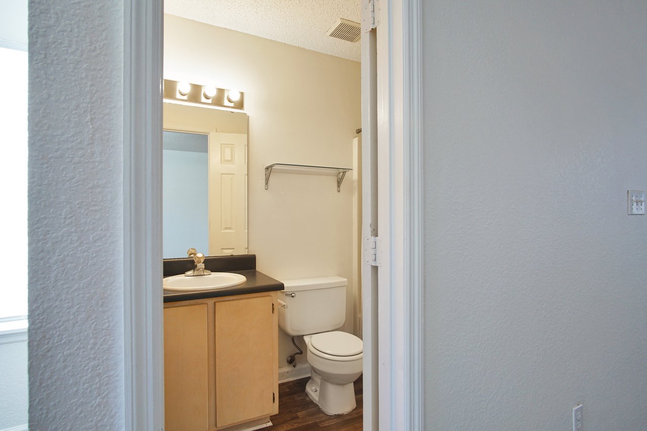 A clean bathroom featuring a white toilet and a modern sink against a neutral wall.