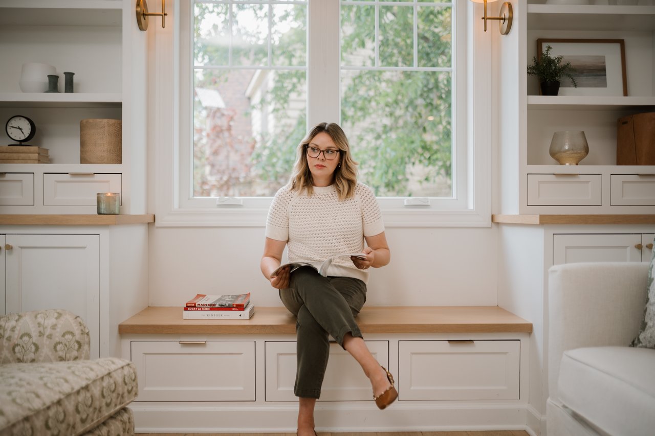 Cait Berry of Insiders Realty sitting in a clean, bright, and thoughtfully organized living space, illustrating the focused editing and smart preparation needed to maximize your sale price in the fast-moving Verona, WI market.