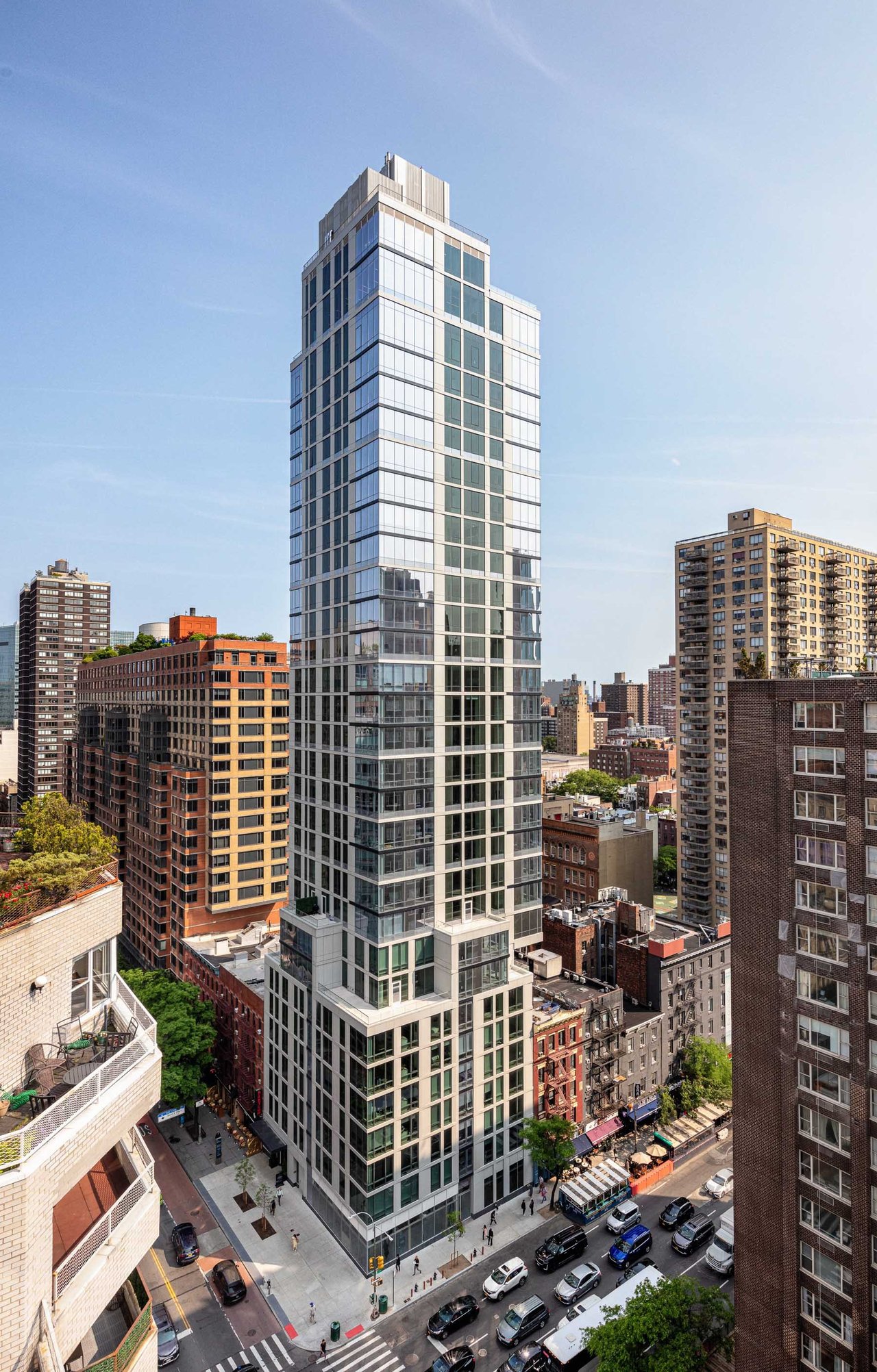 Eastlight tower rises above neighboring buildings at a city intersection.