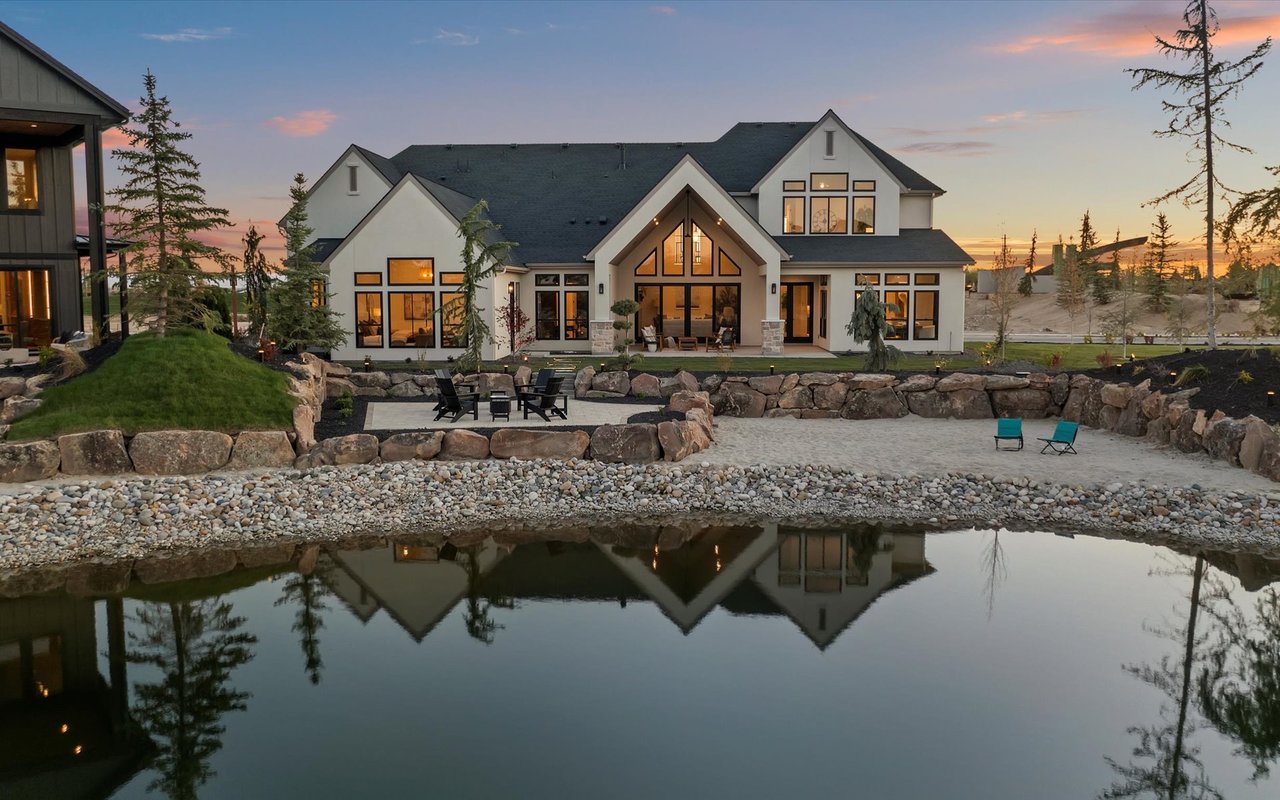 Aerial view of the back of the house, the patio, beach, and part of the lake