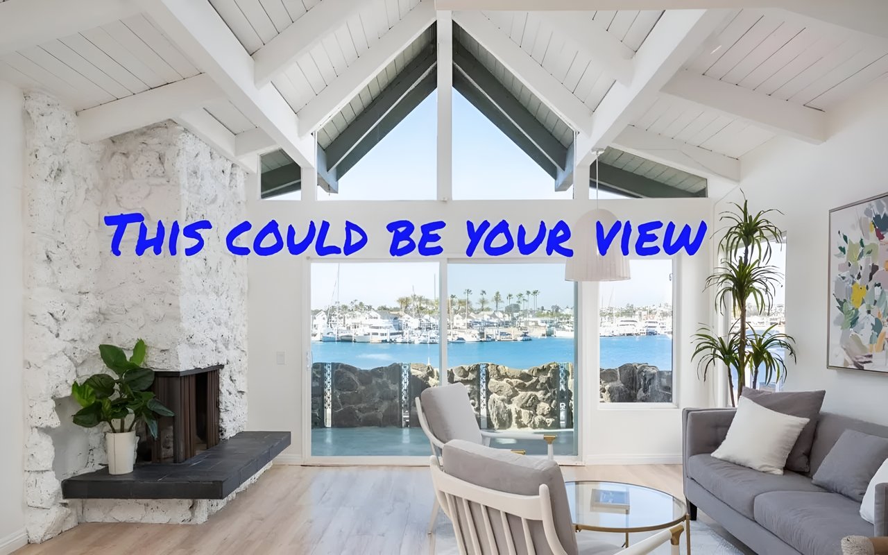 A cozy living room with a fireplace and large windows looks out onto a marina with boats on the water.