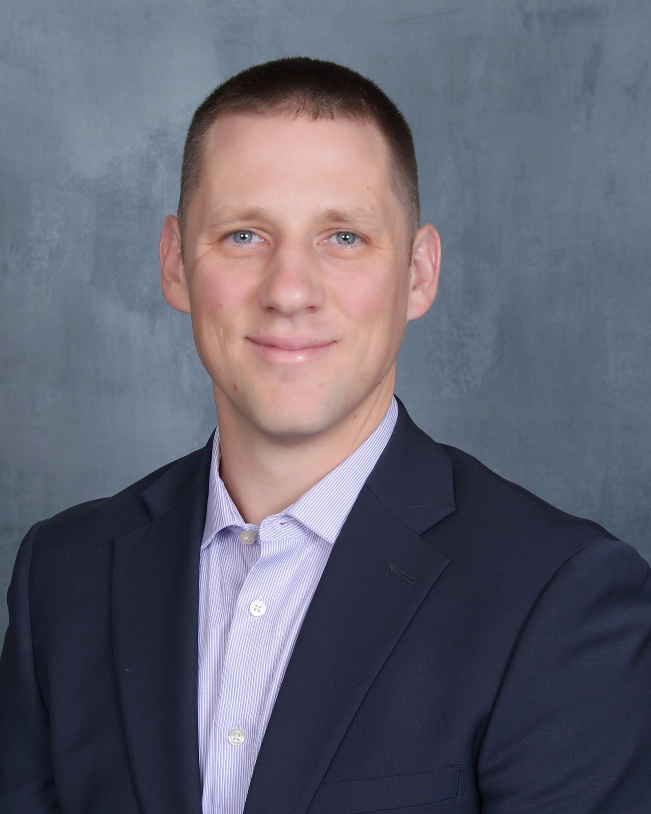 Brian Eby in a navy suit and striped shirt.