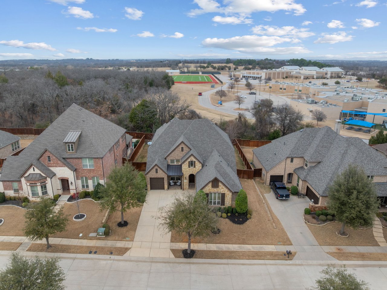 Aerial view of homes in Argyle TX neighborhood near school and residential community in 76226