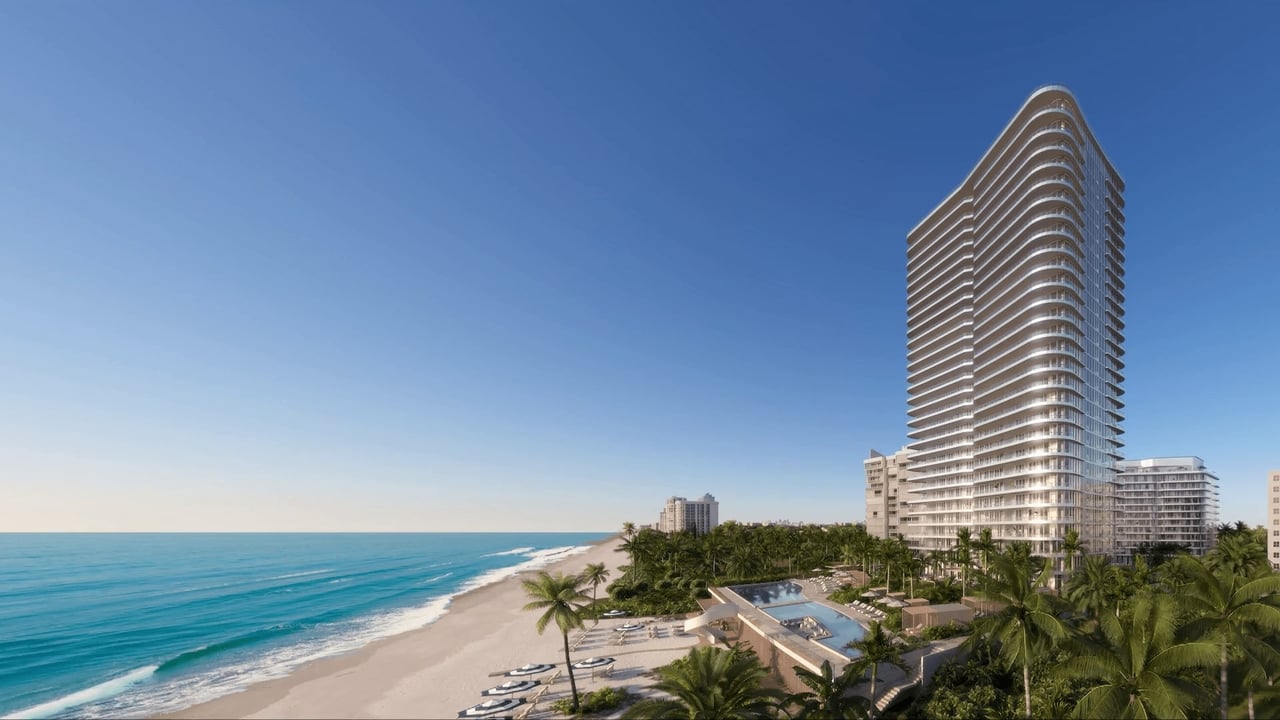 The Ritz-Carlton Residences tower beside a palm-lined beach and oceanfront pool.