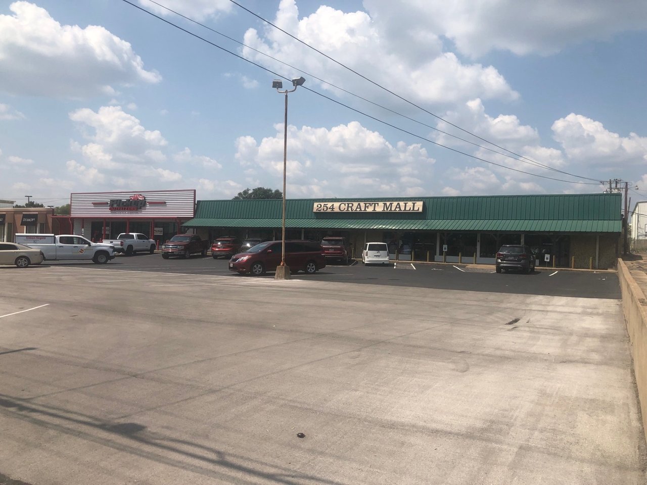 254 Craft Mall storefront with a green metal awning and a large parking lot.