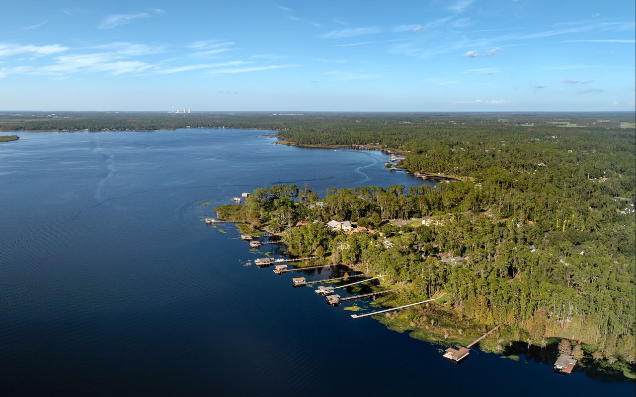 Lake Mary lifestyle representation with tree-lined walkways, landscaped green space, and waterfront scenery.