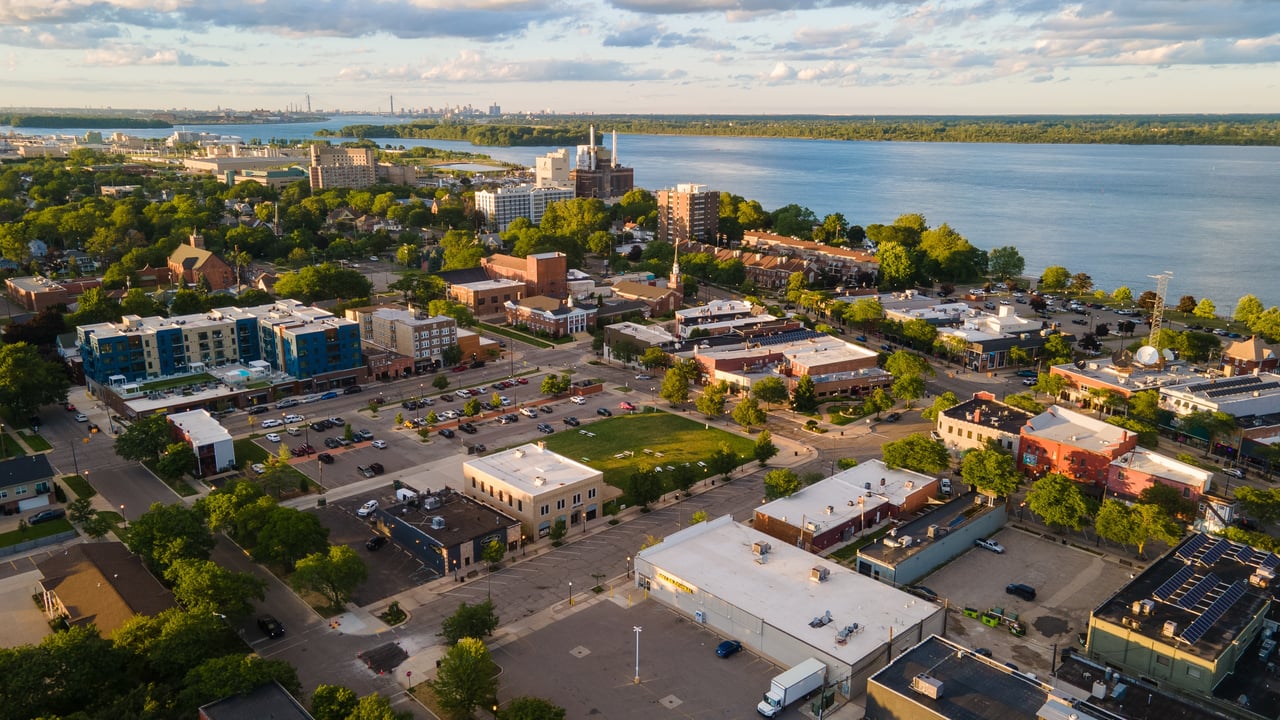 Riverside town with tree-lined streets and low-rise buildings beside a broad river.