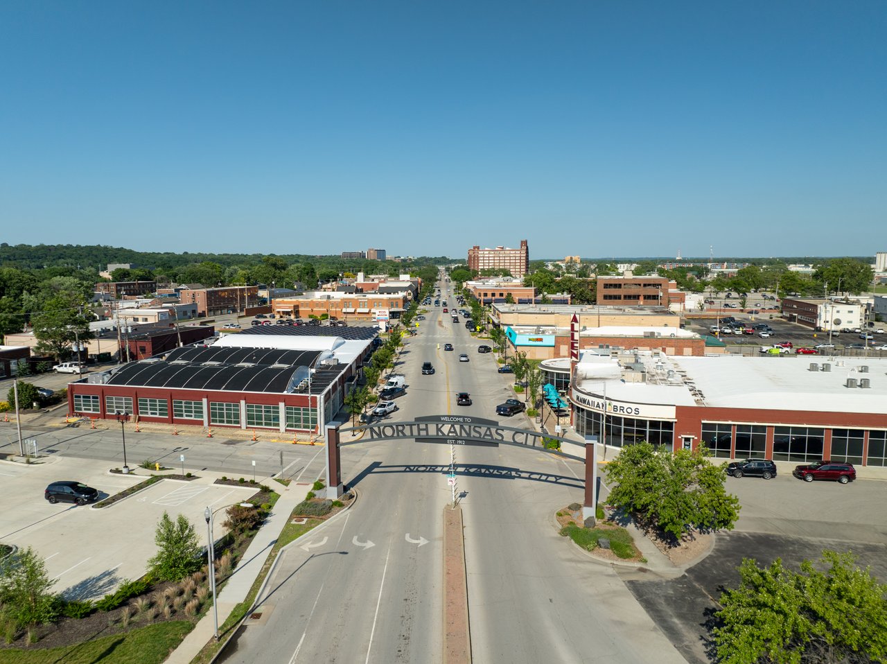 Aerial view of North Kansas City, with its welcome sign spanning the road between downtown buildings.