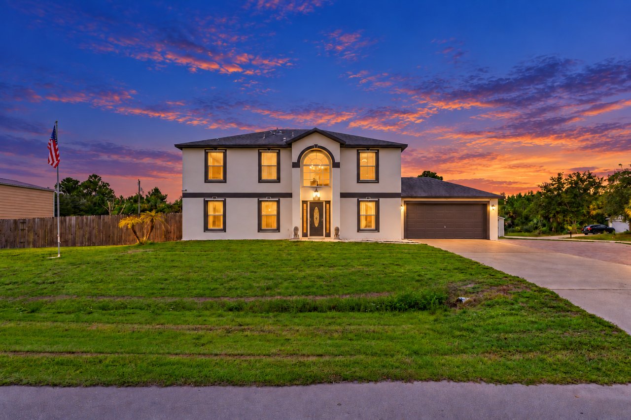 Front exterior of 360 Hanford Rd SW at dusk, a two-story pool home in Palm Bay, FL