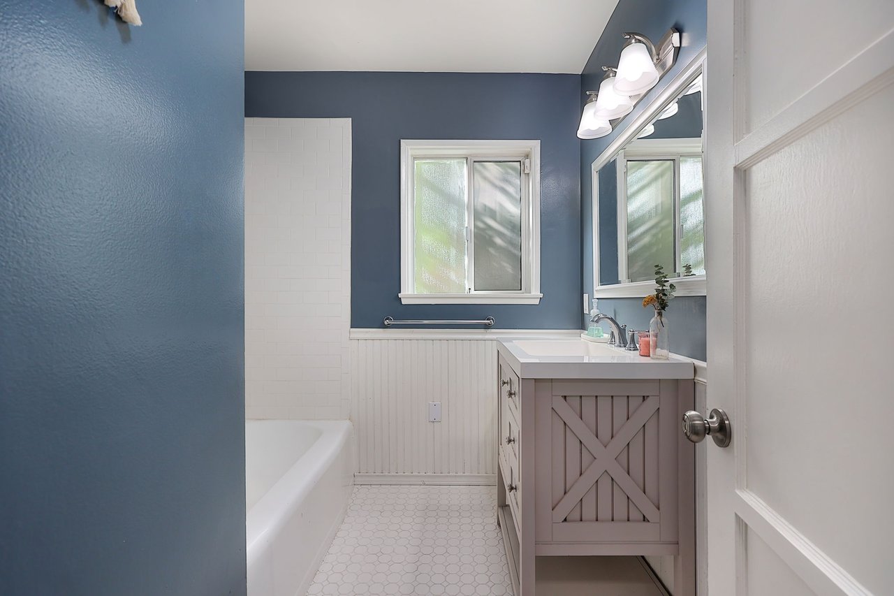 Updated bathroom with farmhouse-style vanity, subway tile, and modern lighting