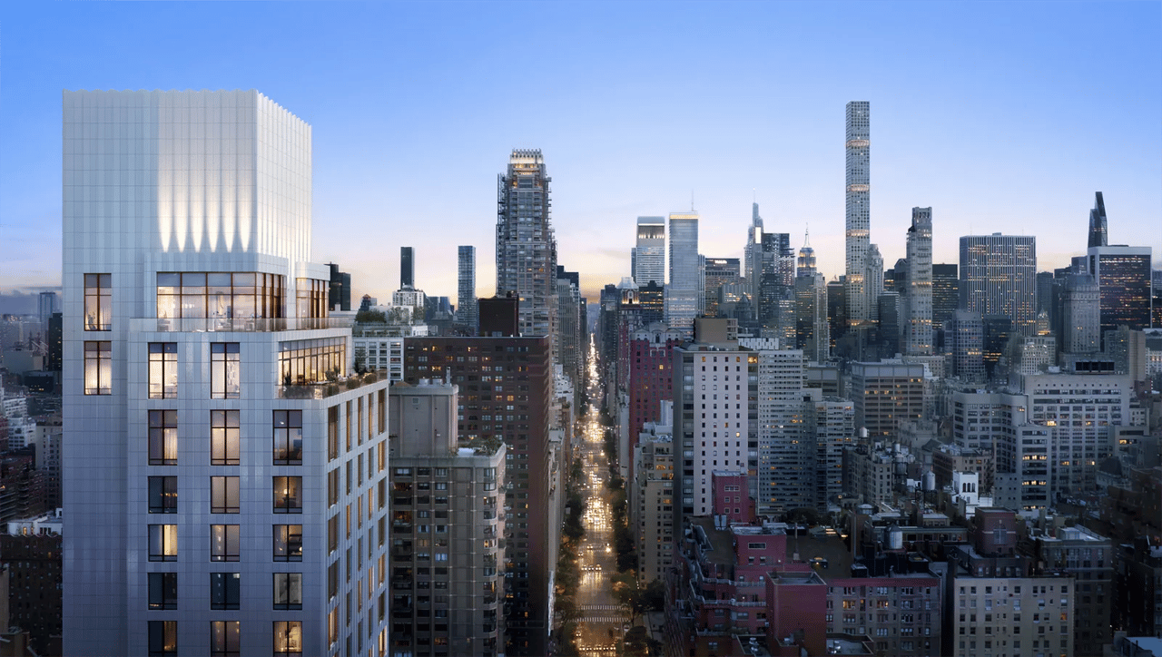 Modern high-rise residential building overlooking the Manhattan skyline at dusk.