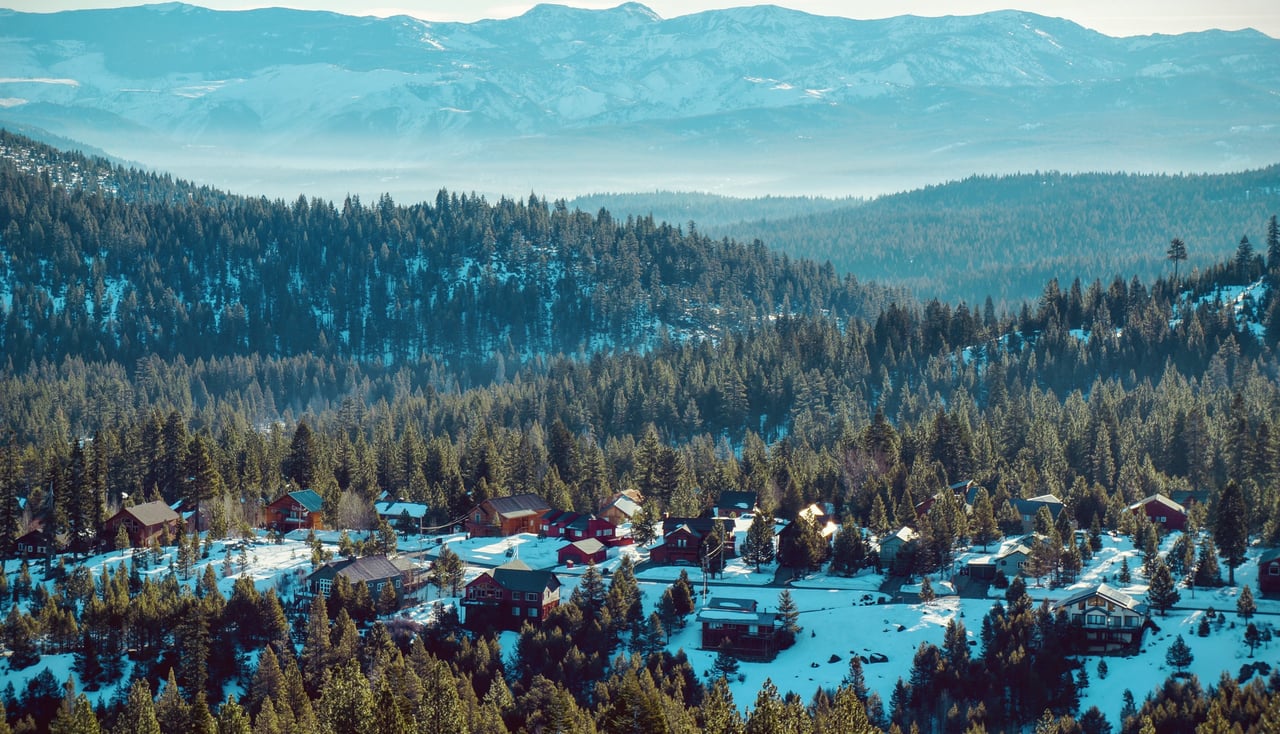 Aerial view of Tahoe Donner neighborhood showing homes, mountains, and forest in Truckee, California