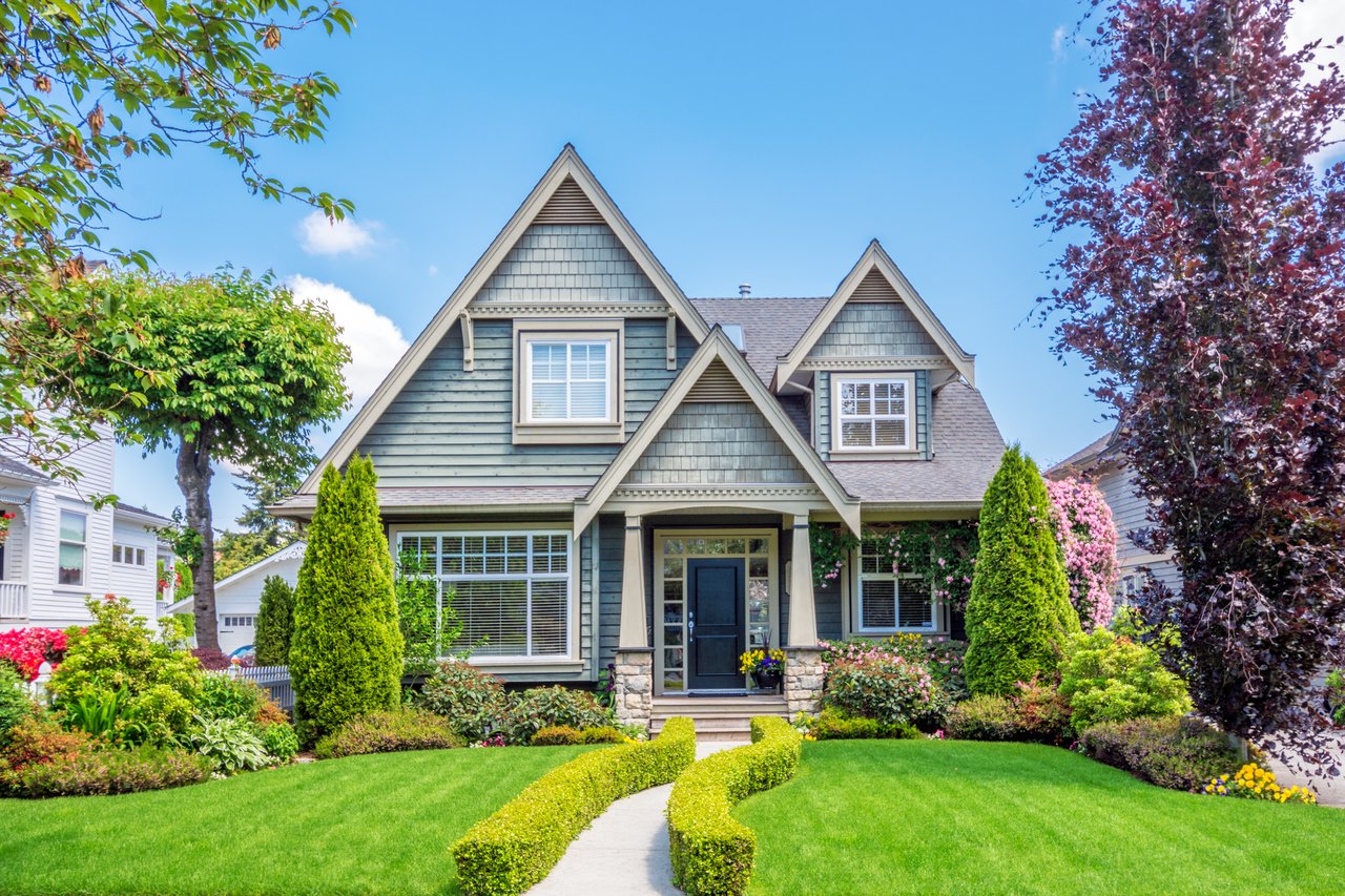Charming single-family rental home with blue siding and manicured landscaping
