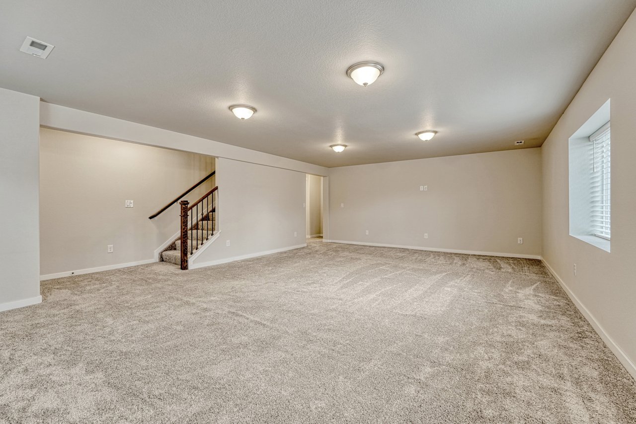 Lower-level family room with stairs up to the main floor