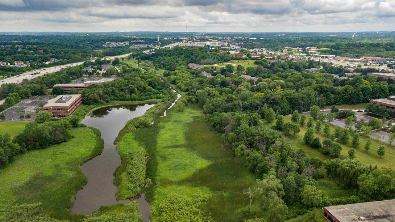 Aerial drone view of Brookfield, Wisconsin featuring office parks, wetlands, and tree-lined landscapes.