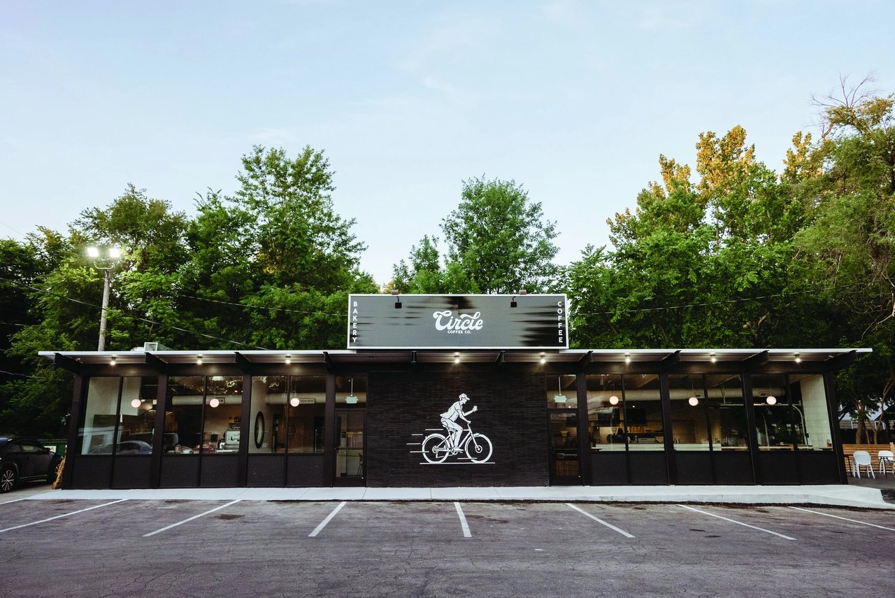 Circle Coffee Co. storefront with a cyclist mural and parking spaces.