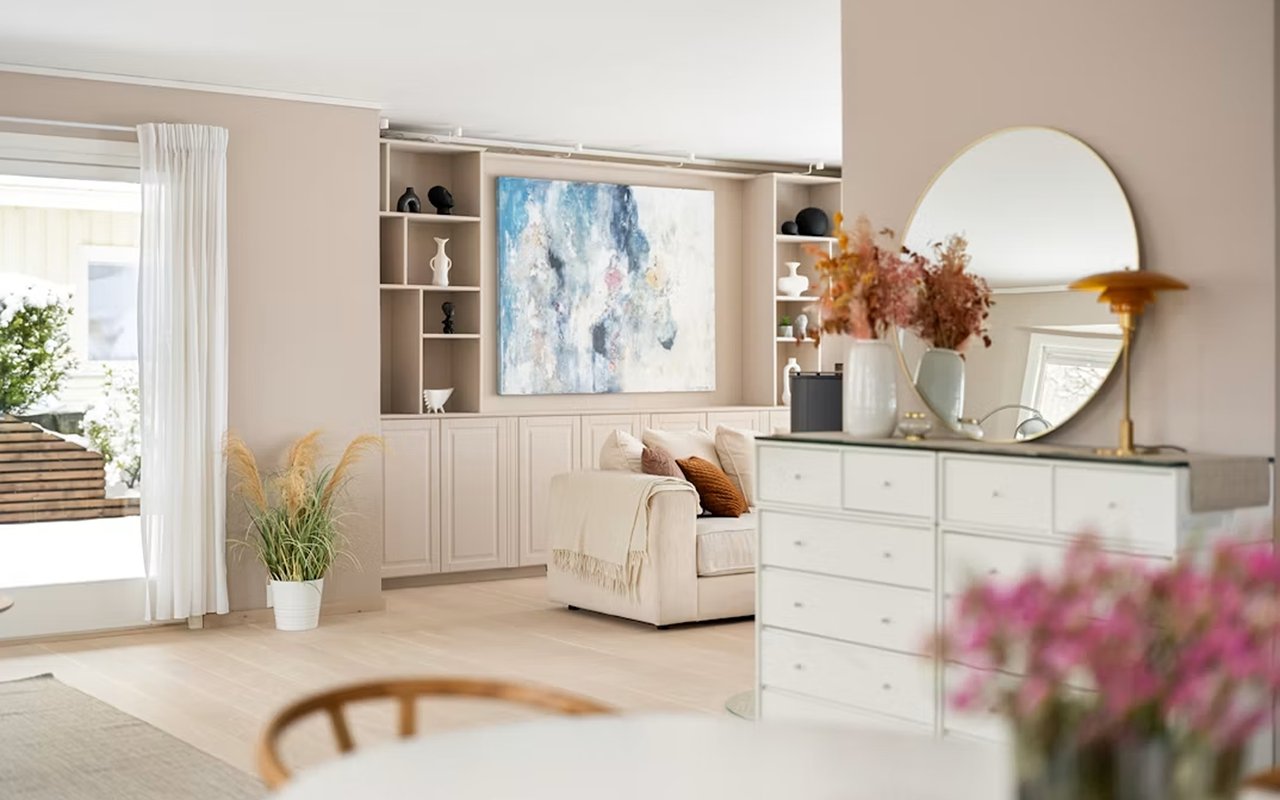Staged bedroom with built-in shelving, a white upholstered bed, and a large round mirror.