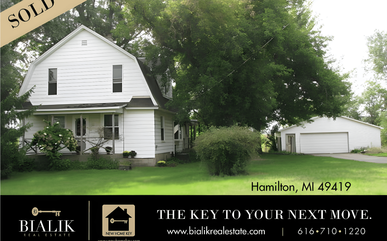 White farmhouse with a front porch and detached garage in Hamilton, Michigan, marked sold.