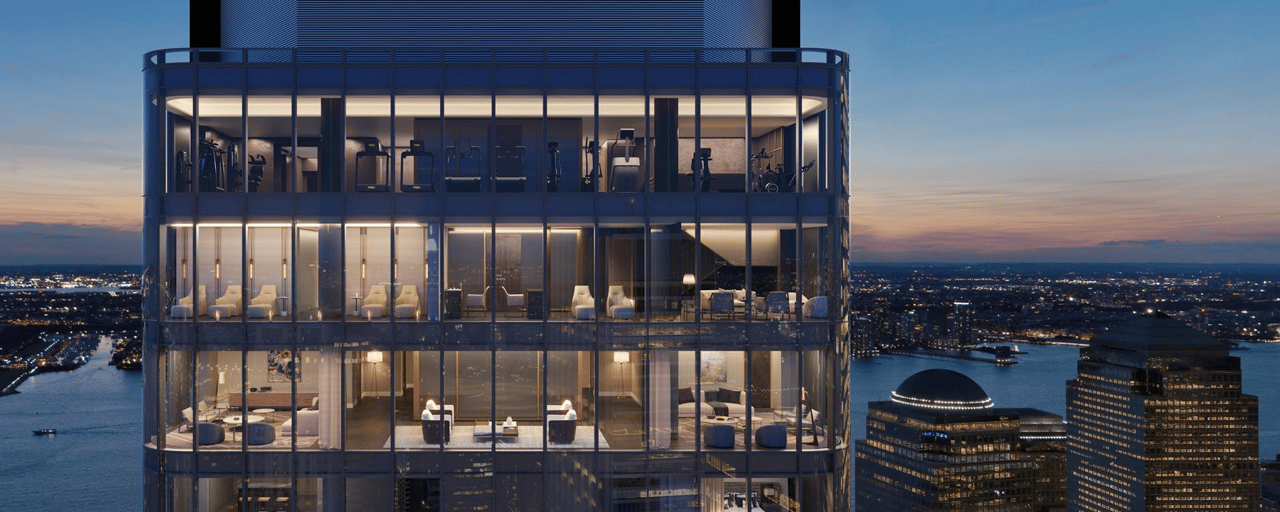 The Greenwich tower’s illuminated glass amenity floors overlook the water and city skyline at dusk.