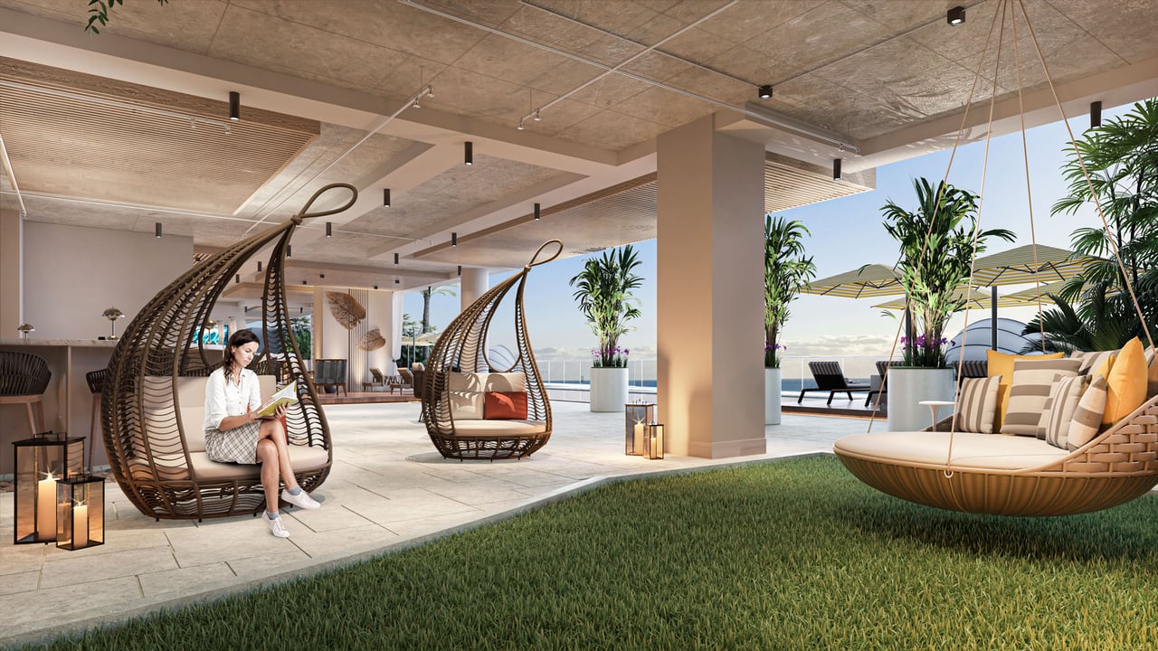 Salato Residences terrace with hanging chairs, tropical plants, lawn, and water views.