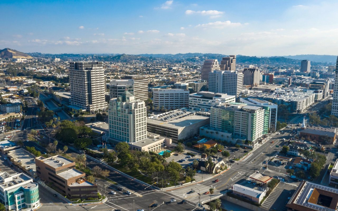 Aerial view of downtown Glendale, with office towers and neighborhoods backed by distant hills.