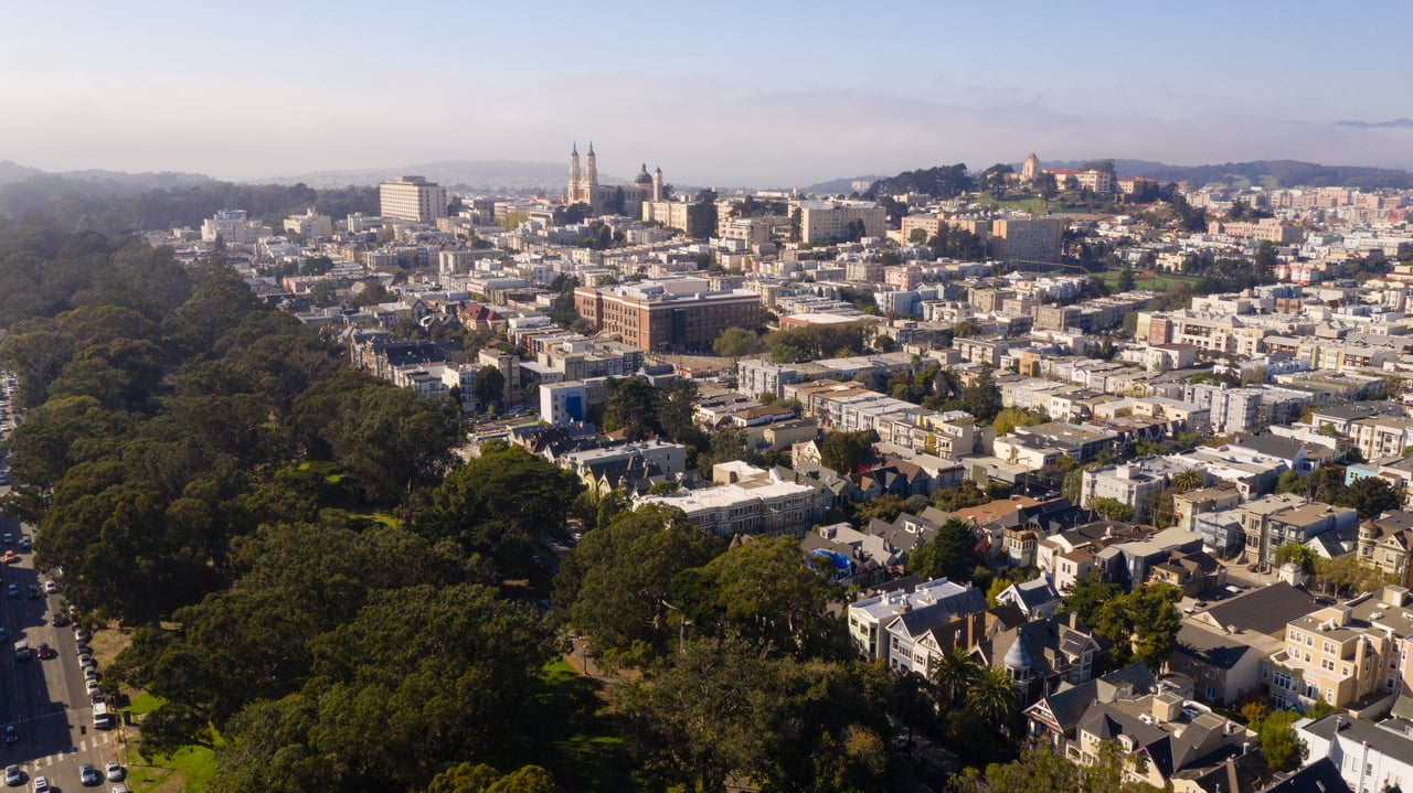 Aerial view of San Francisco’s NoPa neighborhood with tree-lined streets, classic homes, and nearby landmarks including Golden Gate Park and the University of San Francisco.