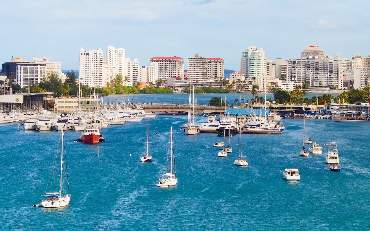 San Juan waterfront skyline behind a marina crowded with sailboats and yachts.