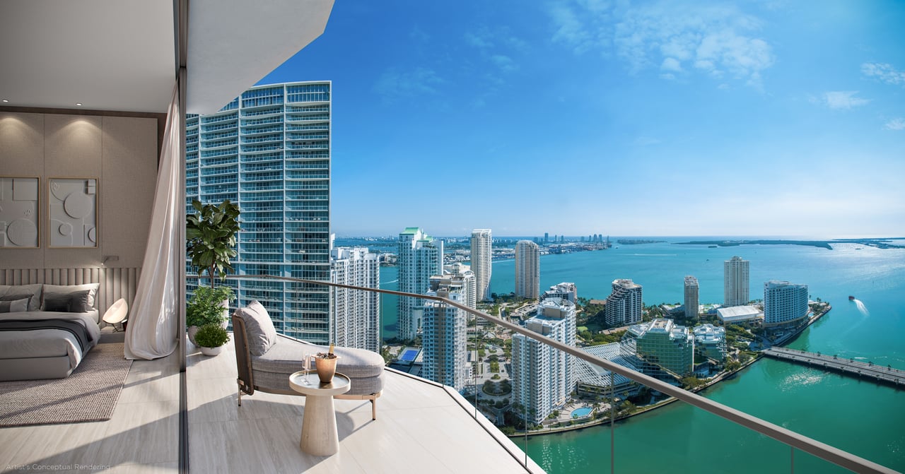 Bedroom and balcony overlooking turquoise bay water and Brickell high-rises.