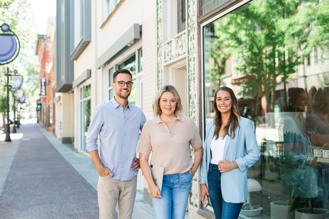 Cait Berry and the Insiders Realty team standing on the walkable Monroe Street sidewalk in Madison, Wisconsin, ready to help clients sell their historic neighborhood homes.