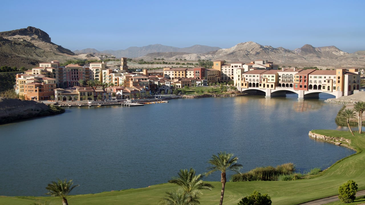 Lake Las Vegas waterfront resort buildings and bridge, with desert mountains beyond.