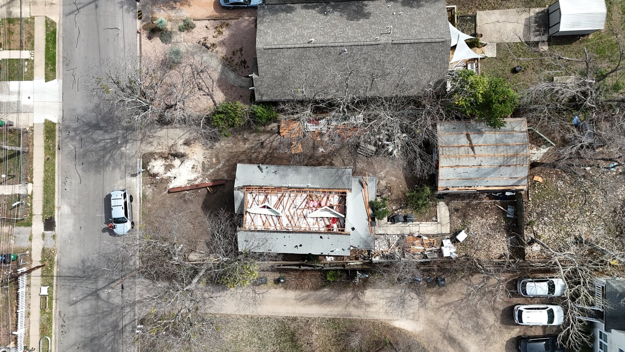 House under construction with exposed roof framing, viewed from above.
