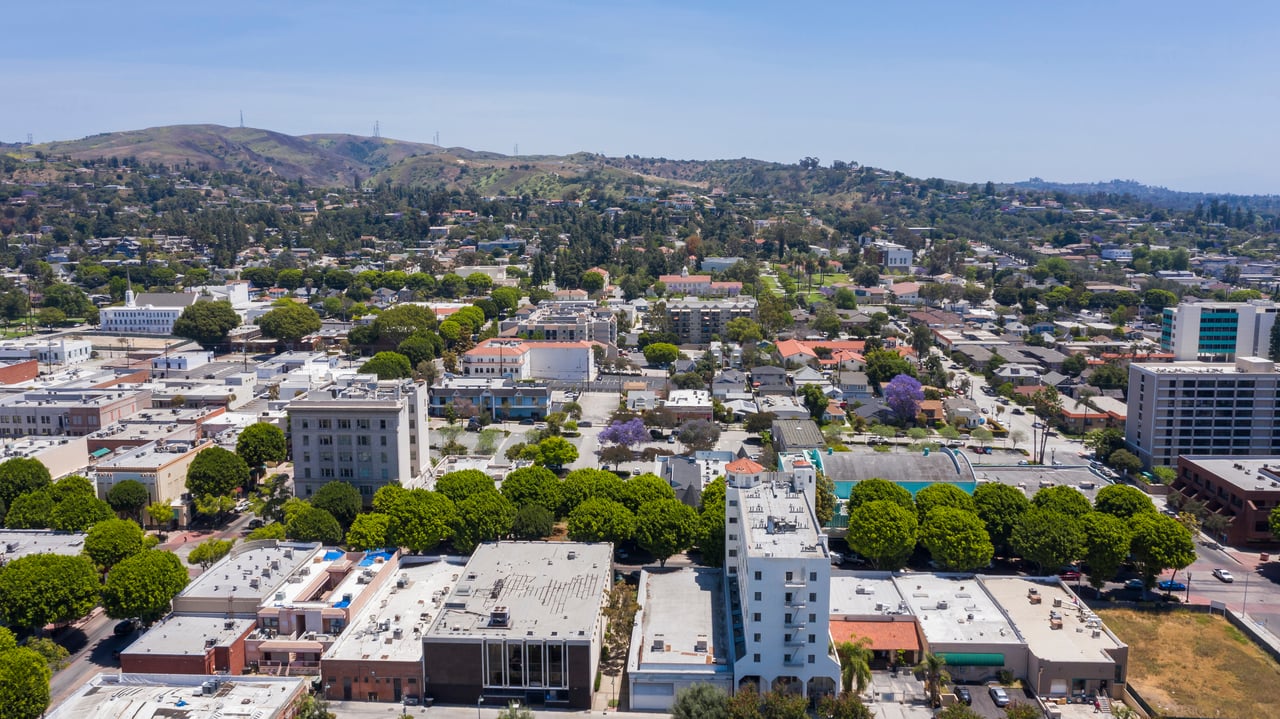Aerial view of Culver City’s low-rise downtown, tree-lined streets, and surrounding hills.